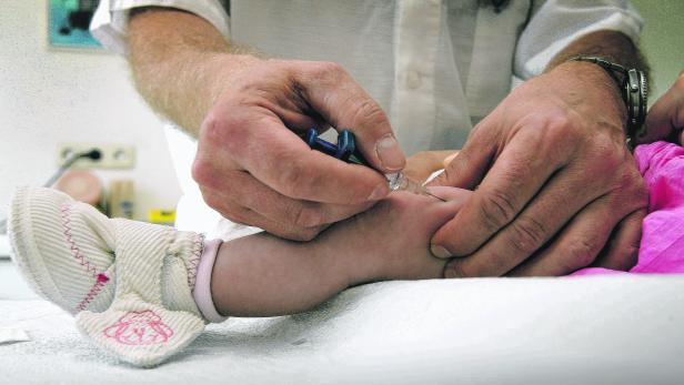 Ein Arzt gibt einem Baby eine Injektion in den Arm.