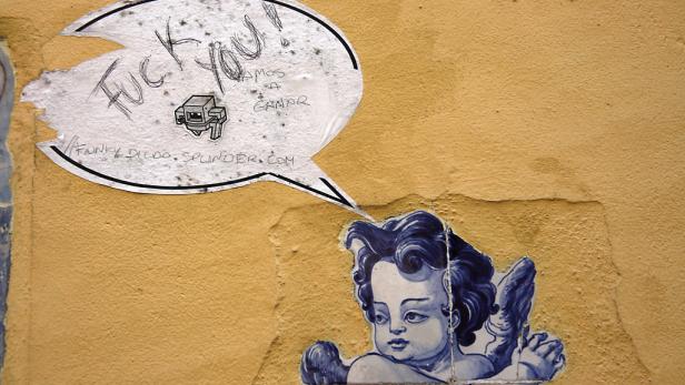 Ein Wandbild zeigt einen Engel unter einer Sprechblase mit der Aufschrift „Fuck you!".