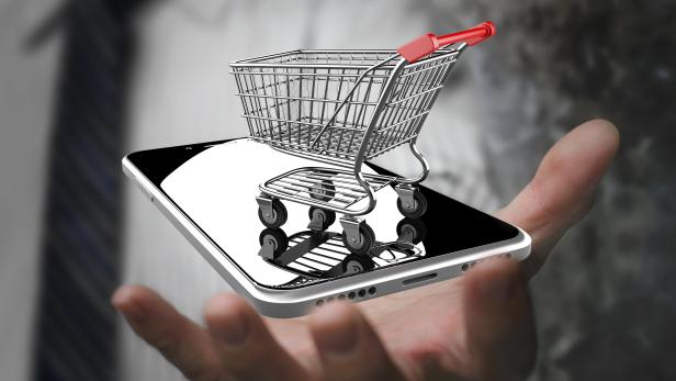 Businessman hand showing shopping cart with smart phone
