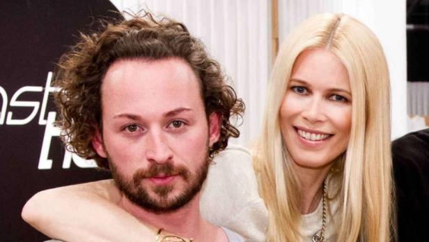 Claudia Schiffer legt ihren Arm um den Hals eines Mannes.