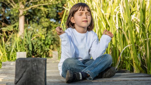 Ein Kind in meditativer Pose.