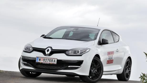 Ein weißer Renault Mégane R.S. mit schwarzen Felgen steht auf einer Anhöhe.