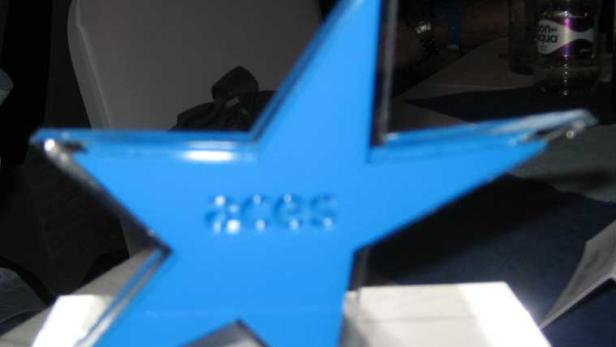 Ein blauer Stern mit der Aufschrift „ACES“ steht auf einem Tisch.