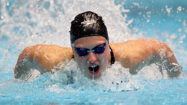 Eine Schwimmerin mit Badekappe und Schwimmbrille schwimmt im Schmetterlingsstil.