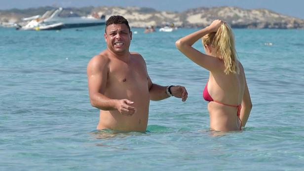 Ronaldo Nazário steht mit einer Frau im türkisfarbenen Wasser.