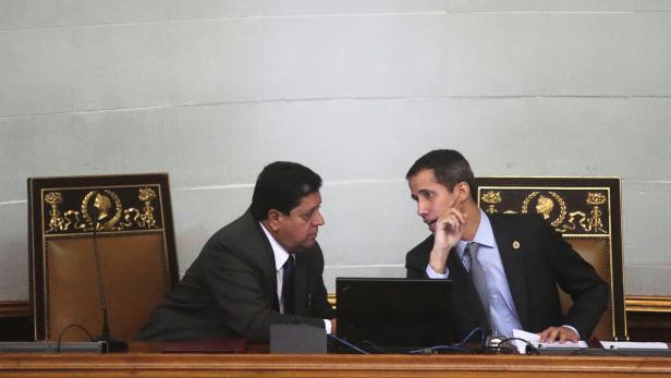 Venezuelan opposition leader Juan Guaido, who many nations have recognised as the country's rightful interim ruler, talks to Edgar Zambrano, the assembly vice president, in a session of the National Assembly in Caracas