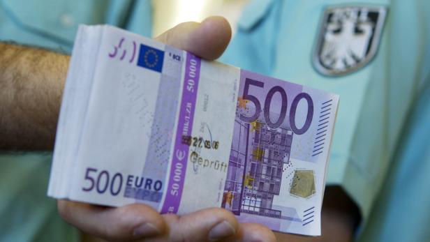 Eine Hand hält einen Stapel 500-Euro-Scheine.