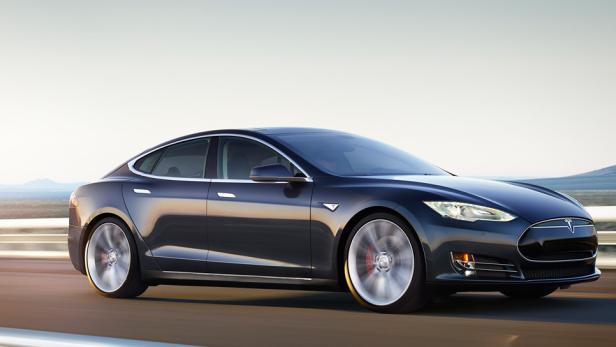 Ein schwarzes Tesla Model S fährt auf einer Landstraße.