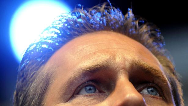 Nahaufnahme des Gesichts eines Mannes mit blauen Augen, beleuchtet von blauem Licht.