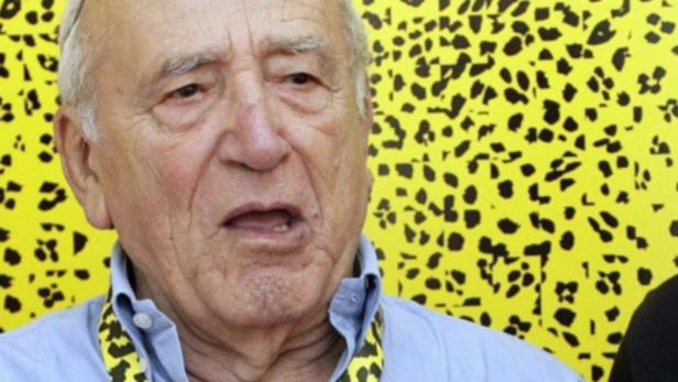 Nahaufnahme eines älteren Mannes vor einem gelben Hintergrund mit schwarzem Leopardenmuster.