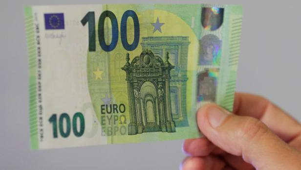 An Austrian central bank official displays a new 100 euro banknote in Vienna