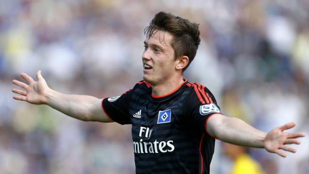 Ein Fußballspieler im Trikot des Hamburger SV jubelt mit ausgestreckten Armen.