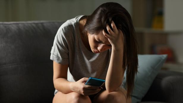 Sad teen being victim of cyber bullying online