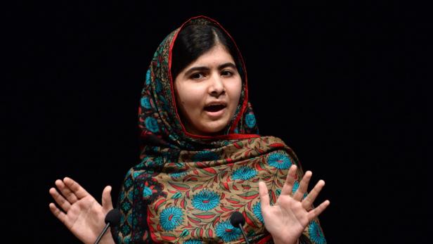 Malala Yousafzai hält eine Rede vor einem dunklen Hintergrund.