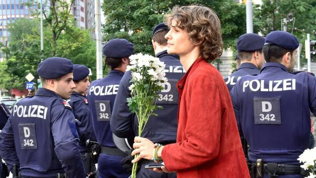 Ein Demonstrant protestiert mit Blumen gegen Gewalt.