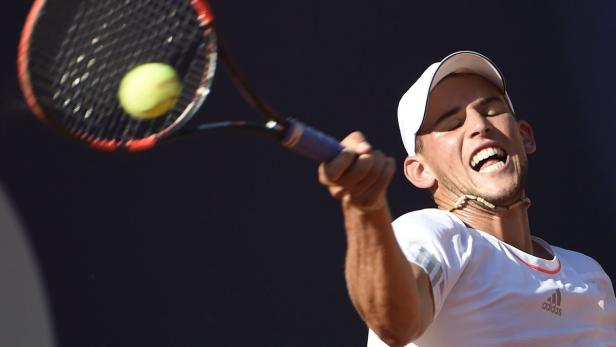 Dominic Thiem schlägt einen Tennisball mit seinem Schläger.