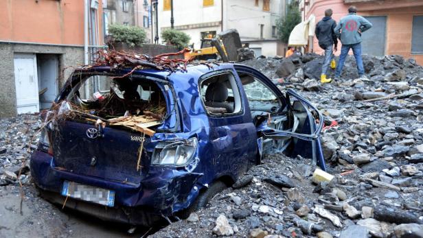 Ein blauer Toyota Yaris ist durch eine Schlammlawine stark beschädigt worden.