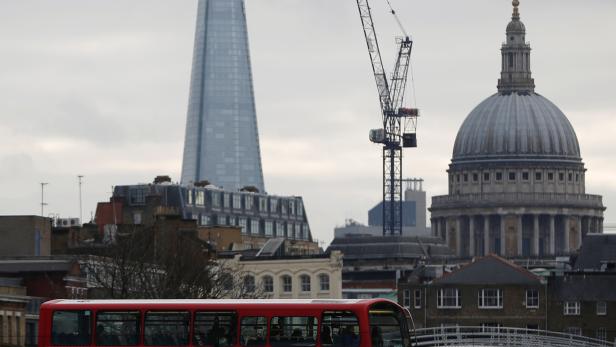 FILE PHOTO: A red bus passes in front of St Paul's Cathedral and the Shard building in London, Britain