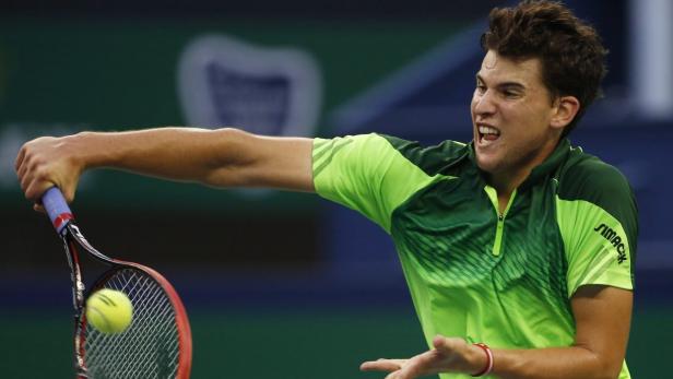 Dominic Thiem schlägt einen Tennisball mit seinem Schläger.