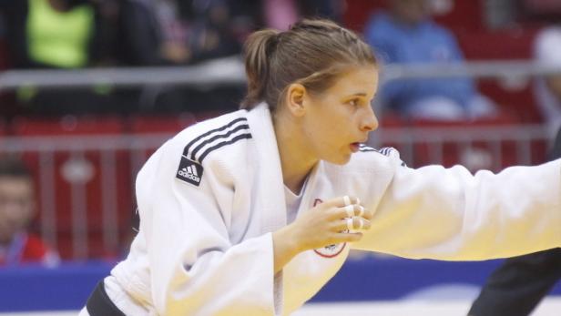 Eine Judoka in einem weißen Judoanzug während eines Kampfes.