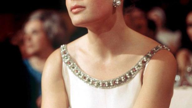 Romy Schneider in einem weißen Kleid mit Schmuck am Ausschnitt.