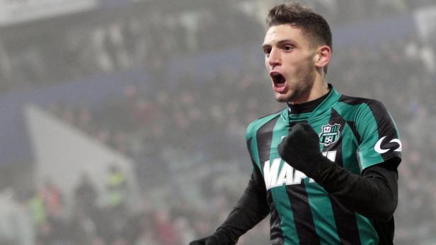 Ein Fußballspieler jubelt mit geballter Faust auf dem Spielfeld.