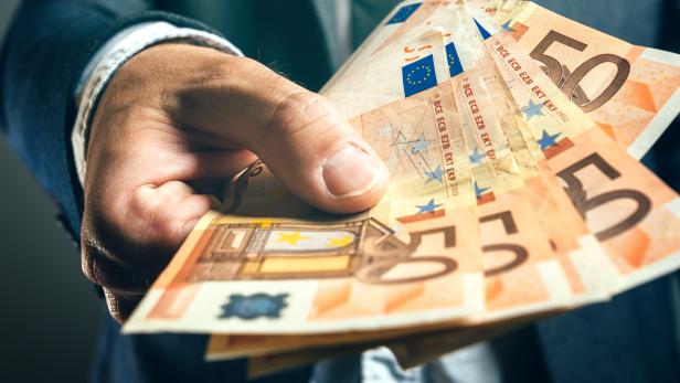Businessman from bank offering money loan in euro banknotes