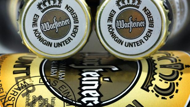 Nahaufnahme von Warsteiner Bierflaschen und -deckeln.