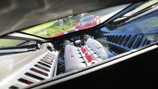 Einblick in den Motorraum eines roten Ferrari Sportwagens.