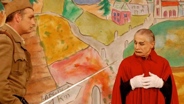 Zwei Schauspieler stehen vor einem gemalten Bühnenbild.