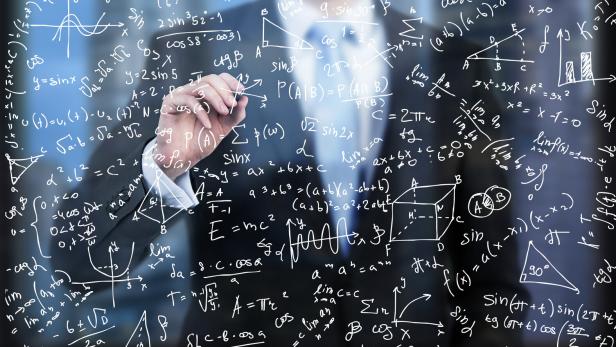 Mann im Anzug schreibt Rechnungen auf Glasscheibe