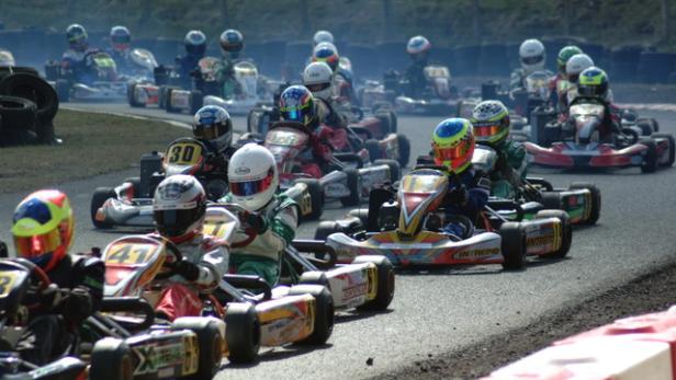 Eine Gruppe von Karts rast auf einer Rennstrecke.