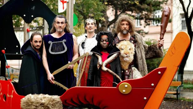 Eine Gruppe von als historische Figuren verkleideten Menschen posiert auf einem Spielplatz.