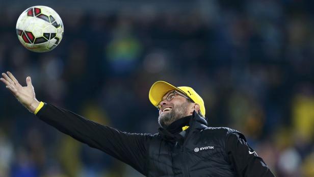 Jürgen Klopp wirft einen Fußball in die Luft.