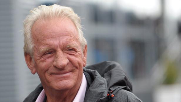 Ein älterer Mann mit hellen Haaren lächelt in die Kamera.