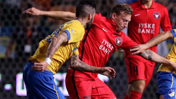 Zwei Fußballspieler kämpfen um den Ball während eines Spiels.