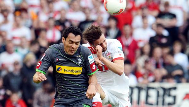 Zwei Fußballspieler kämpfen um den Ball während eines Spiels.