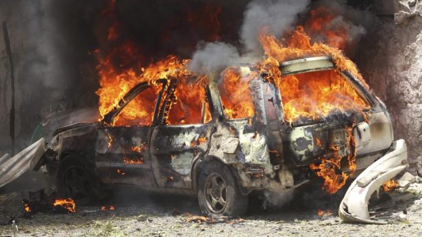 A car goes up in flames near the scene of a blast A car goes up in flames near the scene of a blast in Mogadishu April 14, 2013. At least 16 people were killed as two car bombs exploded outside the law courts in Somalia's capital Mogadishu and gunmen stormed the building on Sunday, before a gunbattle erupted with security forces besieging the compound, witnesses said. REUTERS/Feisal Omar (SOMALIA - Tags: CIVIL UNREST POLITICS)
