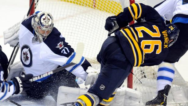 Winnipeg Jets defenseman goalie Ondrej Pavelec (31) deflects a shot by Buffalo Sabres left wing Thomas Vanek (26) during the third period of their NHL hockey game in Buffalo, New York February 19, 2013. REUTERS/Doug Benz (UNITED STATES - Tags: SPORT ICE HOCKEY)