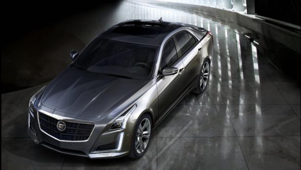 Ein grauer Cadillac CTS steht in einem modern beleuchteten Raum.