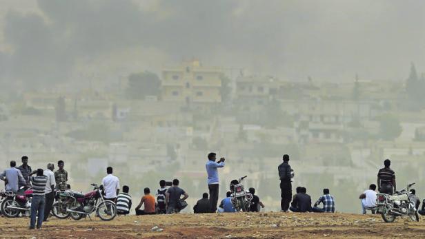 Aus sicherer Distanz beobachten Kurden aus Kobane den Kampf um ihre Stadt.