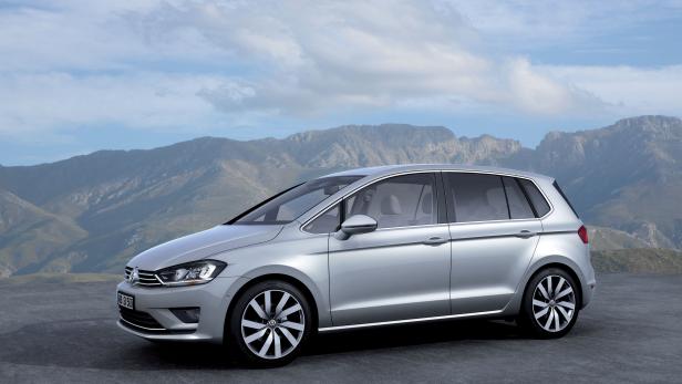 Ein silberner VW Golf steht vor einer Bergkulisse.