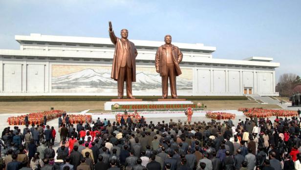 Eine Menschenmenge versammelt sich vor Statuen von Kim Il-sung und Kim Jong-il in Nordkorea.