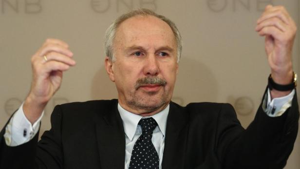 Ein Mann im Anzug gestikuliert mit erhobenen Händen.