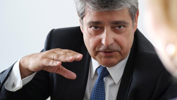 Ein Mann im Anzug gestikuliert während eines Gesprächs.