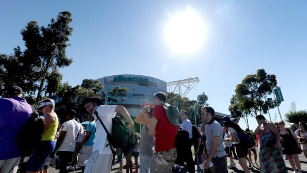 Eine Menschenmenge versammelt sich vor der Hisense Arena unter strahlendem Sonnenschein.