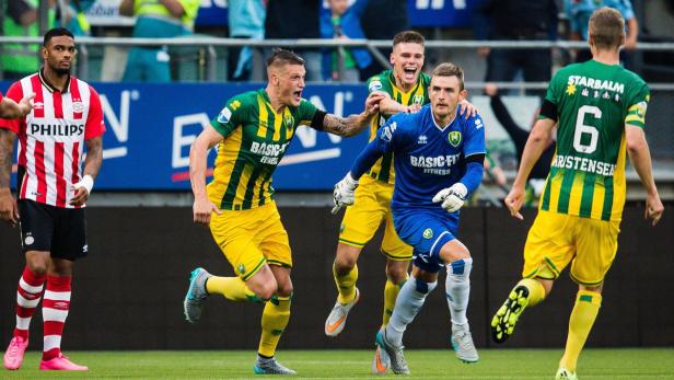 Fußballspieler feiern auf dem Spielfeld ein Tor.