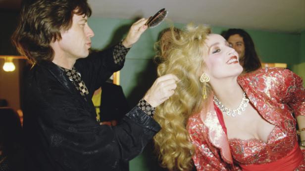 Mick Jagger bürstet Jerry Halls blonde Haare.