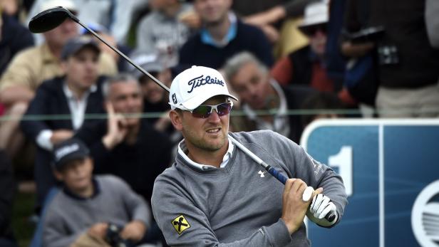 Ein Golfspieler schwingt seinen Schläger vor einer Zuschauermenge.