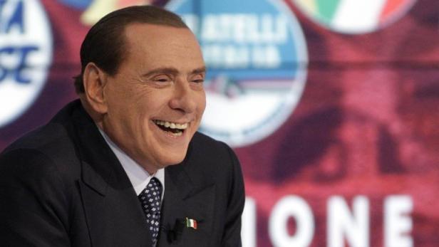 Italy&#039;s former Prime Minister Silvio Berlusconi smiles as he appears as a guest on the RAI television show Porta a Porta (Door to Door) in Rome February 22, 2013. REUTERS/Remo Casilli (ITALY - Tags: POLITICS ELECTIONS)